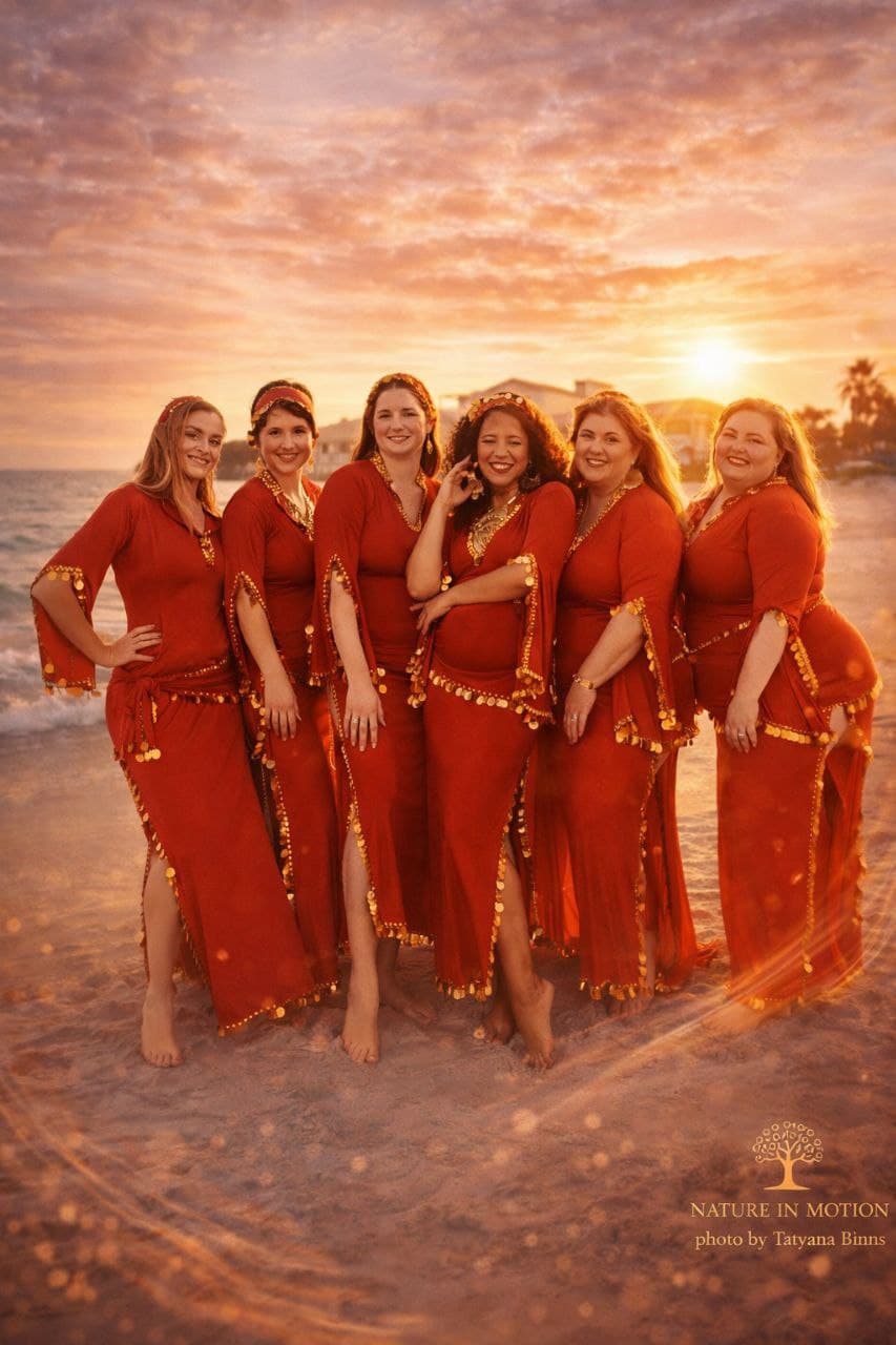 Nature in Motion group in red dresses at sunset